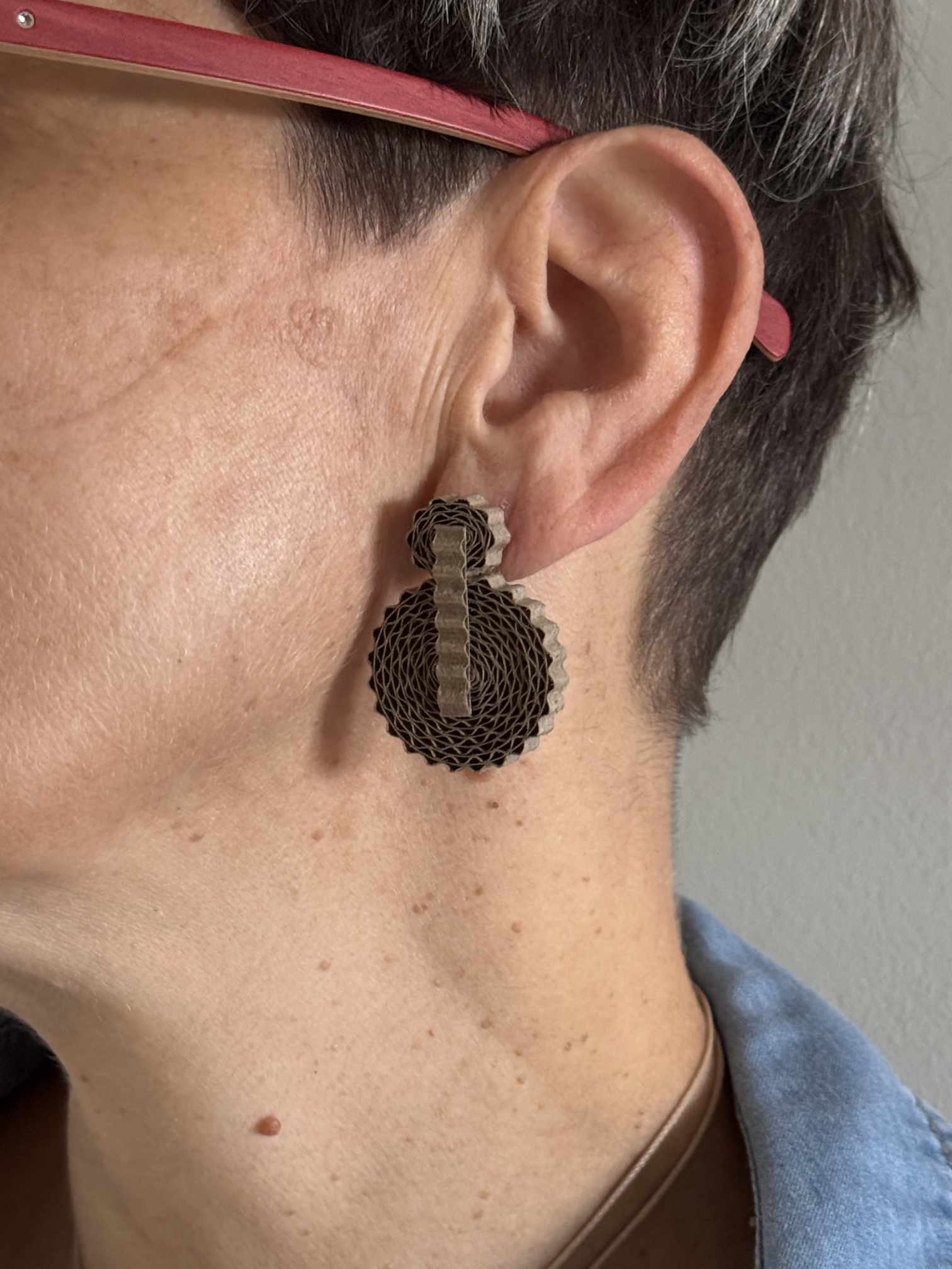 Style bohème avec les boucles d'oreilles écoresponsables Corolle couleur naturel portées de profil