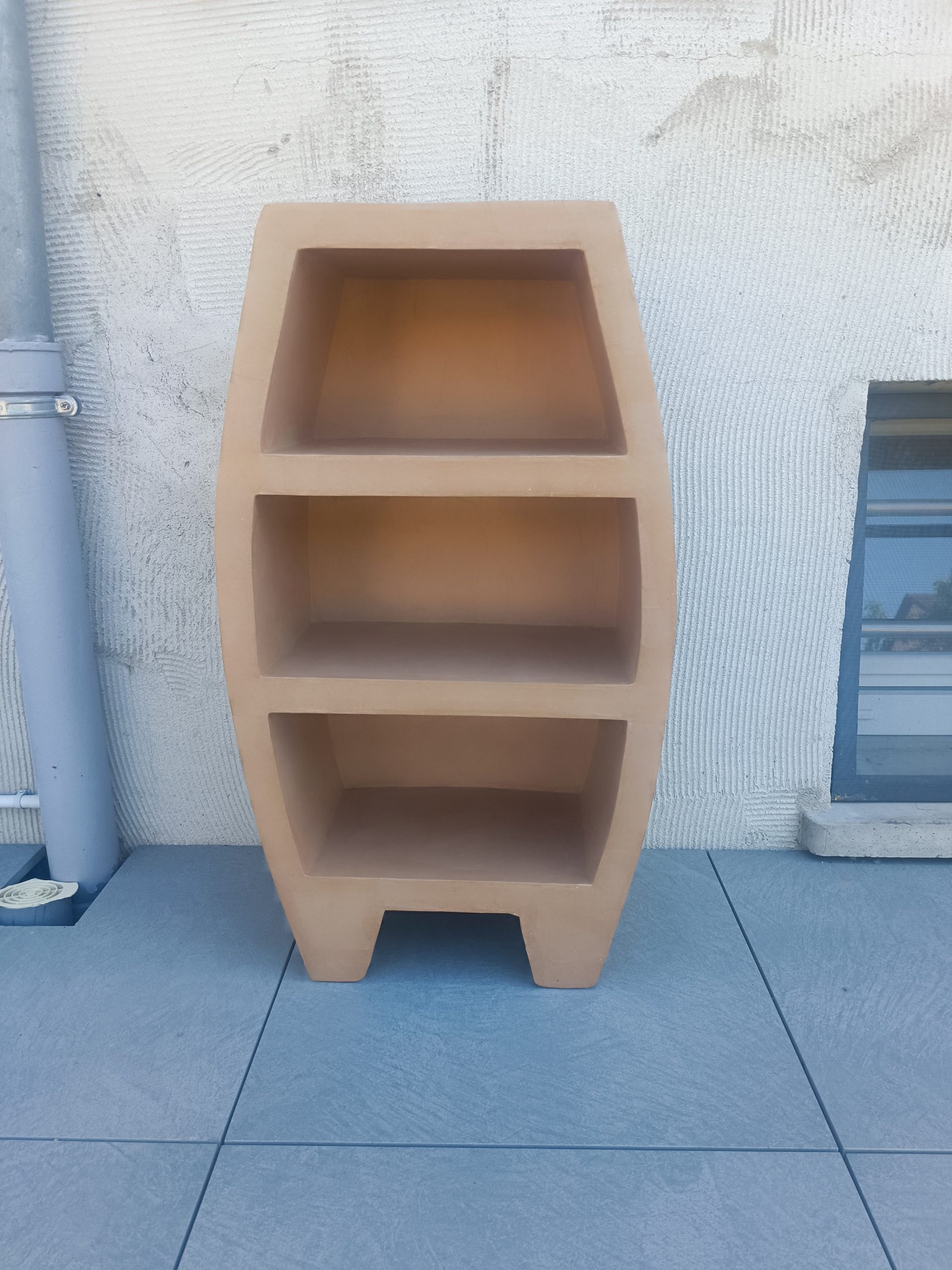 Petite bibliothèque moderne de forme galbée à trois niches, revêtement beige aspect kraft